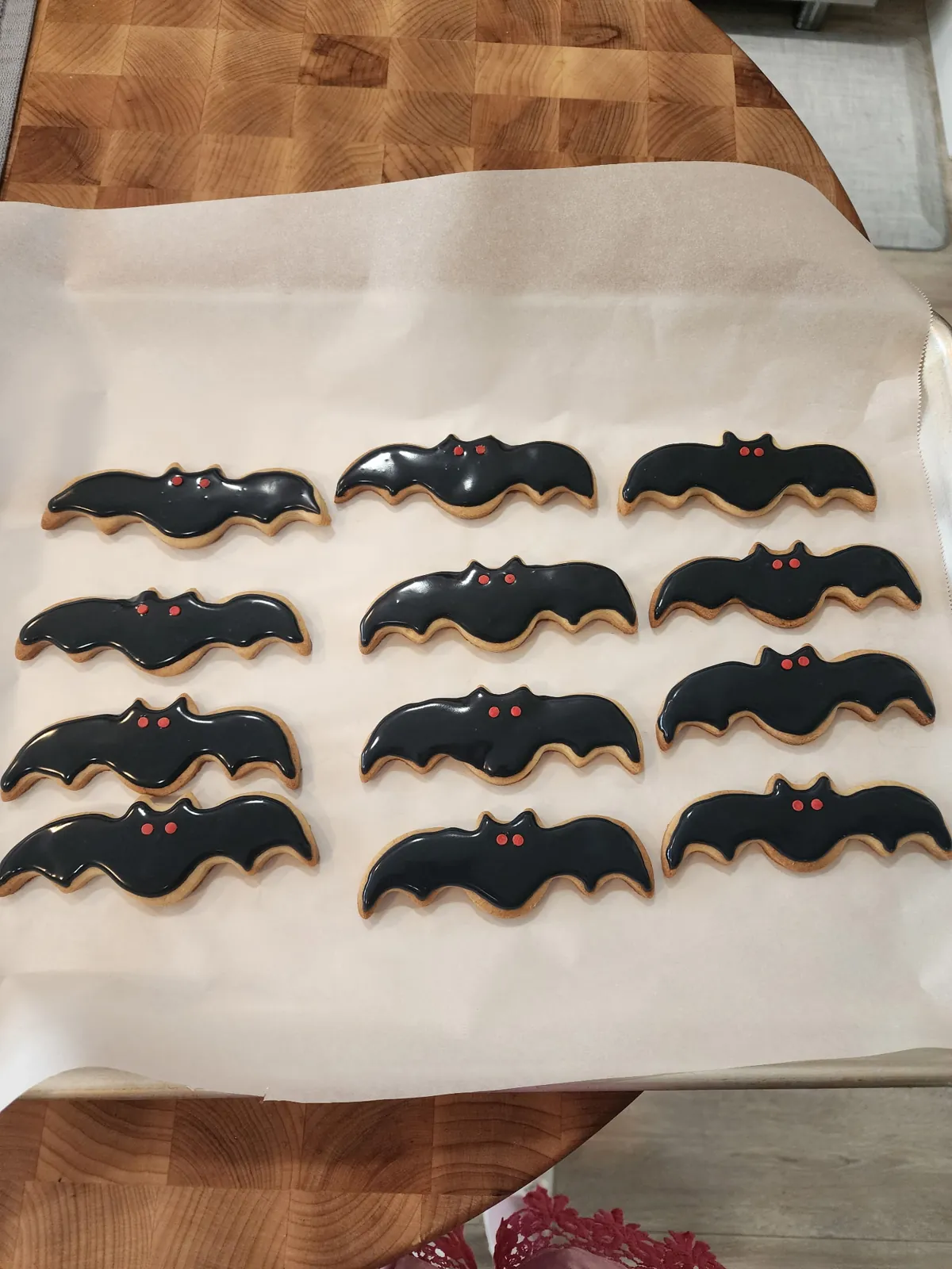Bat-shaped sugar cookies with black icing and red eyes